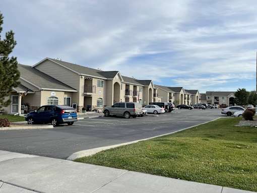 A row of houses with cars parked in front.