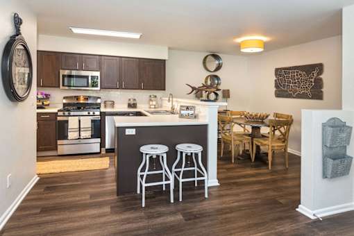 A kitchen with a bar stool and a dining table.