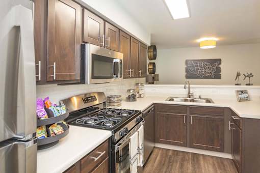 A kitchen with wooden cabinets and a stainless steel refrigerator.