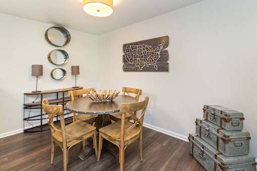 A dining room with a wooden table and chairs.