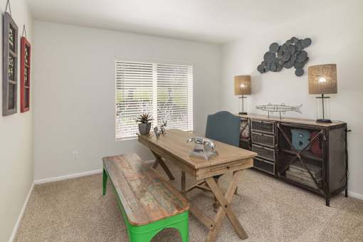 A room with a wooden table and a green bench.