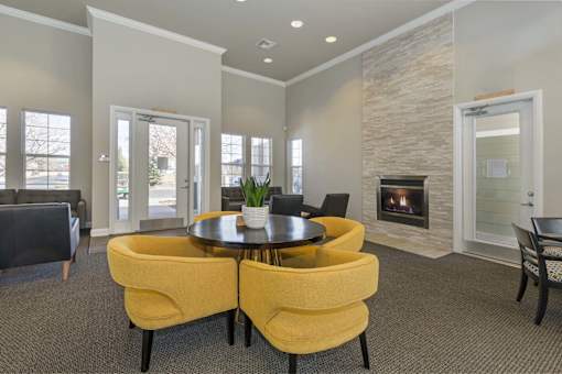 A living room with a fireplace and a table with chairs.