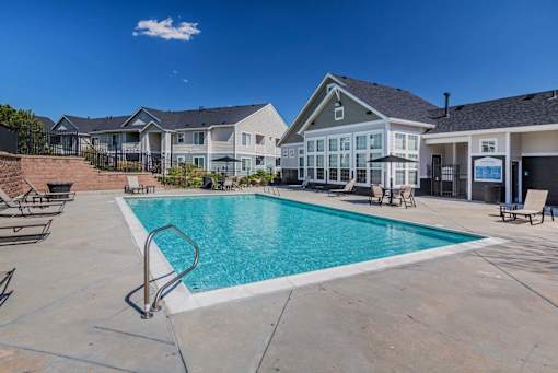 A swimming pool in a residential area with houses in the background.