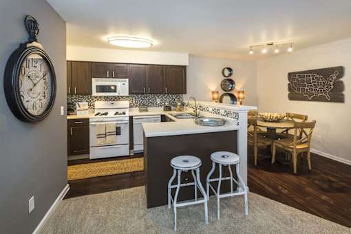 A kitchen with a white stove top oven and a white microwave above it.