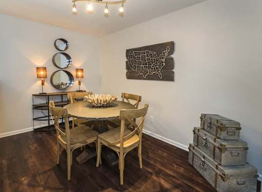 A dining room with a wooden table and chairs.