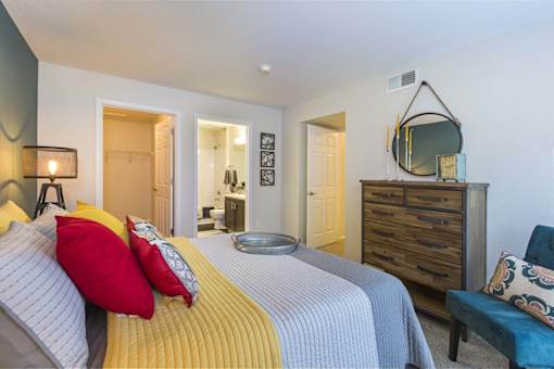 A bedroom with a bed, dresser, and mirror.