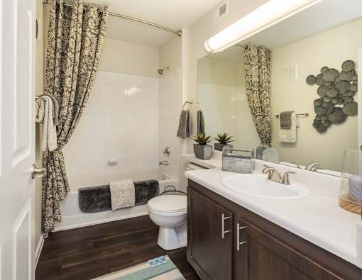A bathroom with a toilet, sink, and shower.
