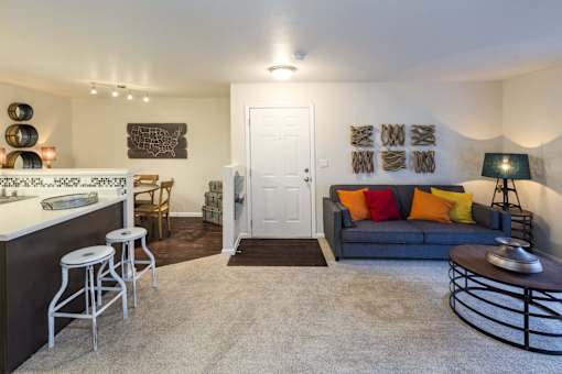 A living room with a grey couch and a white door.