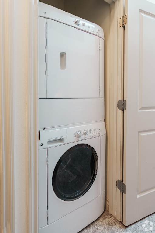 A white dryer and washer are in a small space.