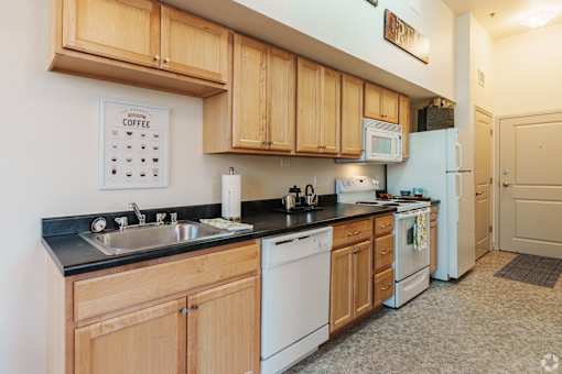 A kitchen with wooden cabinets and a white fridge.