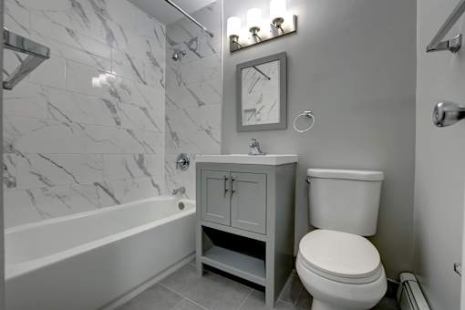 A bathroom with a marble wall and a white toilet.