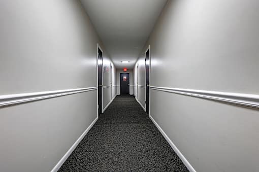 A long, narrow hallway with a red light at the end.