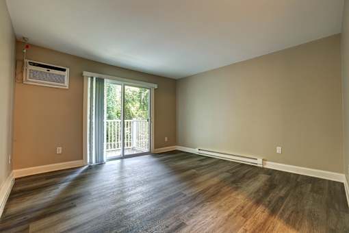 A room with a sliding glass door leading to a balcony.