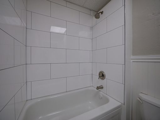 A white bathroom with a tub and a shower.
