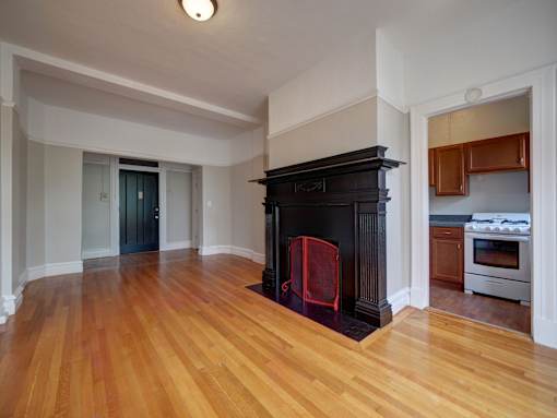 A room with a fireplace and wooden floors.