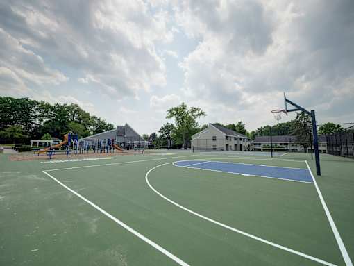 A basketball court with a blue hoop and white lines.