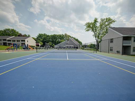 A blue tennis court with white lines and a yellow border.