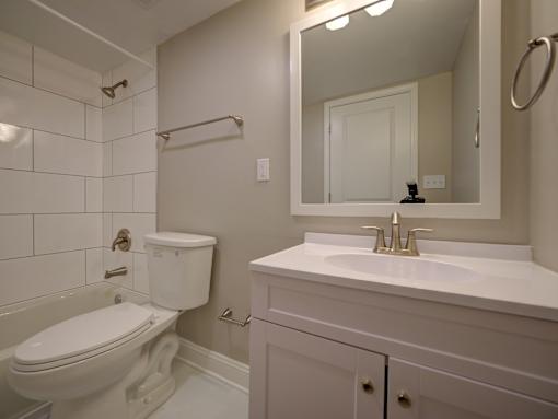 A white toilet sits next to a white sink in a bathroom.