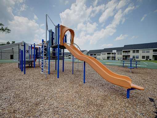 A playground with a slide and climbing structure.