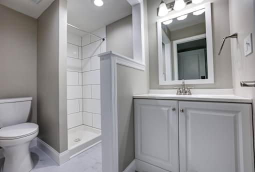 A white toilet sits next to a white sink in a bathroom.