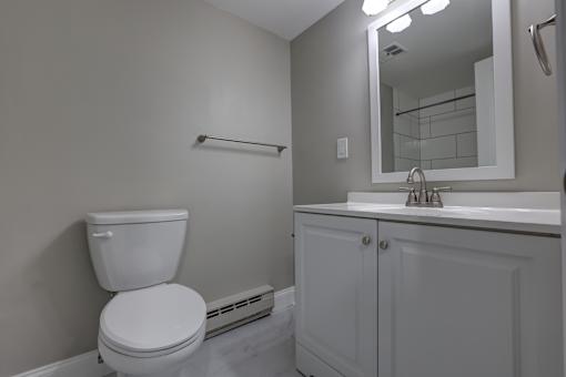 A white toilet sits next to a white sink in a bathroom.