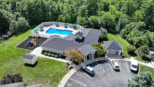 A large house with a pool and a parking lot.