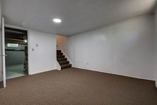 A room with a staircase leading to another room.