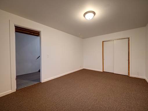 A room with brown carpet and white walls.