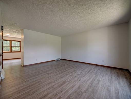 A room with wooden flooring and white walls.