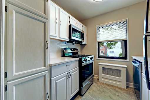 A small kitchen with white cabinets and appliances.