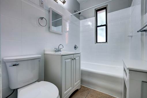 A white toilet sits next to a sink in a small bathroom.