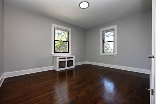 A room with a white bench and two windows.