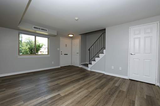 A room with wooden floors and a staircase.