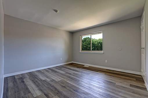 A room with wooden flooring and a window.
