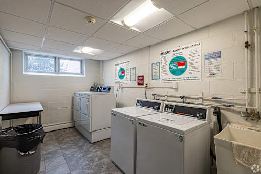 A laundry room with washers and dryers and instructions on the wall.
