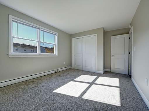 A room with a large window and two doors.