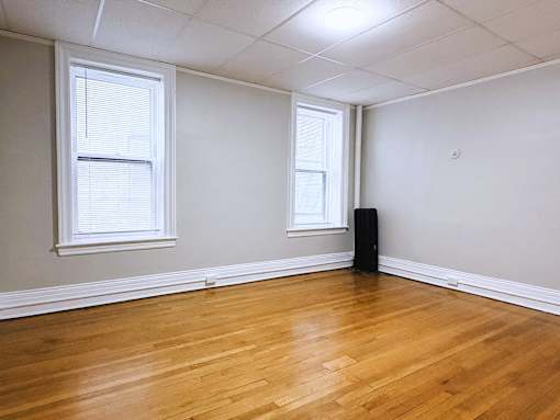 Room with wooden floor and windows at Willett Apartments, Albany, New York