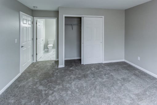an empty room with a closet and a bathroom