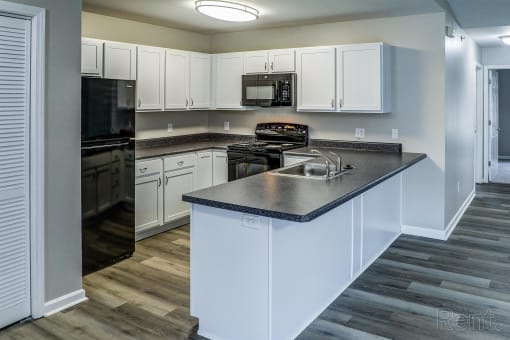 a kitchen with white cabinets and stainless steel counter tops