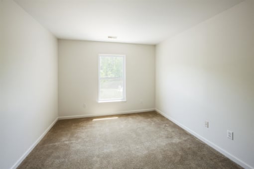 an empty room with carpet and a window