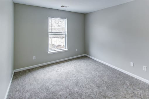 an empty room with carpet and a window