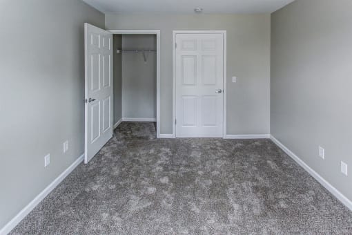 a room with a carpeted floor and a closet