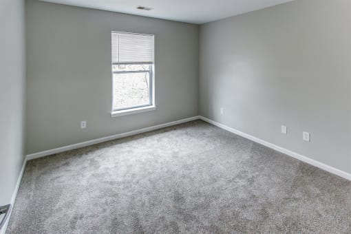 an empty room with carpet and a window