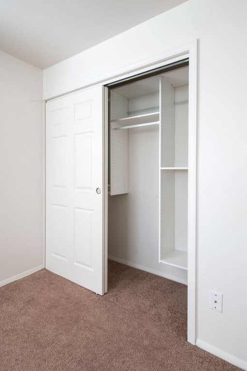 a bedroom with a closet and a door that is open