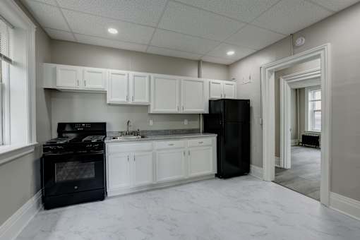 A kitchen with black appliances and white cabinets.