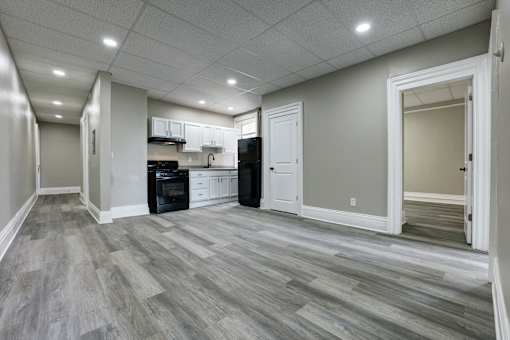 A kitchen with a black oven and white cabinets.