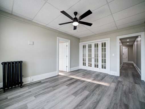 Unfurnished room with white door and fan at Willett Apartments, Albany, New York