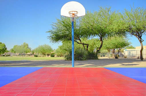 a basketball hoop on a blue pole in a park