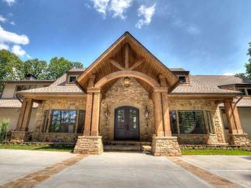the front of a brick house with a black door