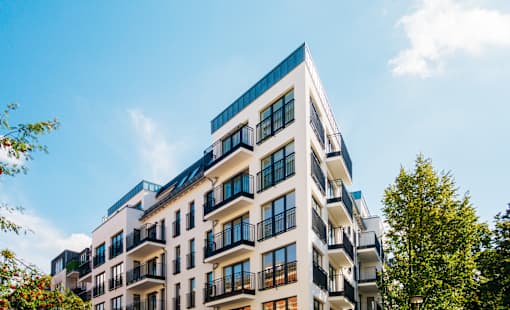 A modern multi-story building with balconies and windows.